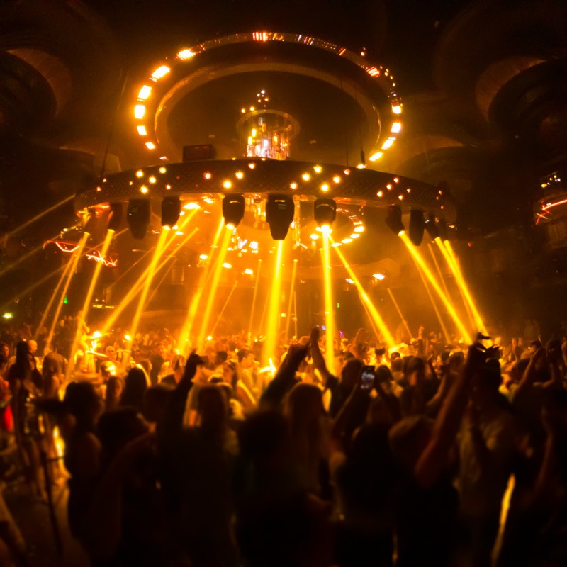 a group of people standing in front of a large crowd at night