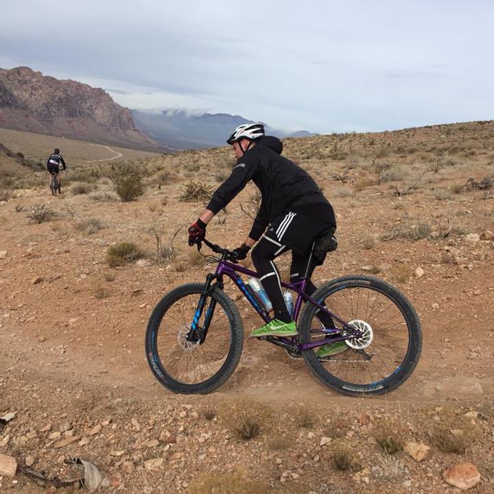 a man riding a bike down a dirt road